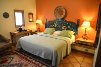 ein Schlafzimmer mit einem großen Bett mit orangefarbenen Wänden in der Unterkunft La Posada Hotel and Gardens in Winslow