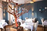 un arbre dans une salle à manger avec des tables et des chaises dans l'établissement Hotel Kasteel Doenrade, à Doenrade