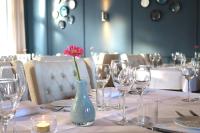 - une table avec des verres à vin et un vase avec une fleur dans l'établissement Hotel Kasteel Doenrade, à Doenrade