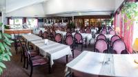 a restaurant with rows of tables and chairs at Hotel Julie in Joensuu