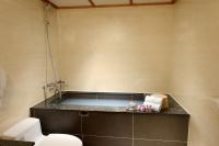 a bathroom with a toilet and towels on a counter at Chyuan Du Spring Resort in Taipei