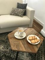 a coffee table with a cup of coffee and a plate of bread at Magnifiques Appartements Hyper Centre in Nantes