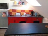a kitchen with red cabinets and a black counter top at Appartements T2 Proche de Rennes in Chantepie
