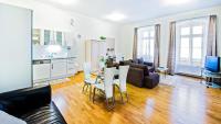 ブラチスラヴァにあるCentral Apartmany Biela streetのソファとテーブルとキッチンのあるリビングルーム