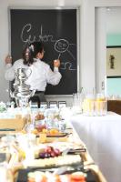 una persona escribiendo en una pizarra sobre una mesa con comida en Landhaus am See, en Garbsen
