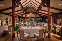 uma sala de jantar com uma mesa e cadeiras brancas em Hunter's Country House em Plettenberg Bay