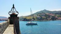 a boat in the water next to a lighthouse at 4SAP22 Appartement climatisé avec double terrasses in Collioure