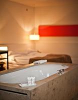 a bath tub in a room with a bed at CORTIINA Hotel in Munich