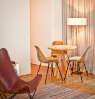 a room with a table and chairs and a lamp at CORTIINA Hotel in Munich