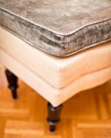 a wooden stool with a grey cushion on top of it at CORTIINA Hotel in Munich