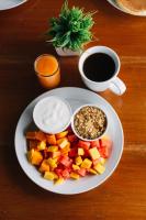 Un plato de comida con fruta y salsa y una taza de café. en Hotel Casa Amelia, en Flores
