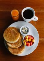 Un plato de panqueques con fruta y una taza de café. en Hotel Casa Amelia, en Flores