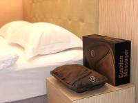 a hat sitting next to a box next to a bed at The Riverside Hotel Hengchun in Hengchun South Gate
