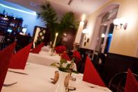 a table in a restaurant with red chairs and candles at Hotel & Restaurant Haus am See in Löcknitz