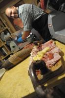 Ein Mann bereitet Fleisch auf einem Schneidebrett zu. in der Unterkunft Agriturismo Sol De Montalto in Rivoli Veronese