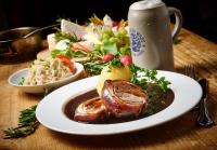 un plato de comida con carne y una ensalada en una mesa en Hotel Gäubodenhof, en Straubing