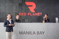 three women standing behind a red planet marina bay sign at Red Planet Manila Bay in Manila