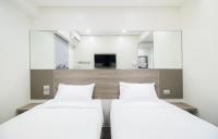 two beds in a room with a tv at Red Planet Manila Bay in Manila