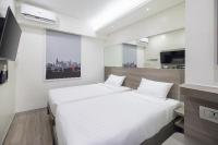 a bedroom with two beds and a television in it at Red Planet Manila Bay in Manila