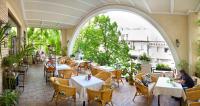 an outdoor patio of a restaurant with tables and chairs at Gostiny Dvor Hotel in Kharkiv