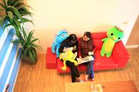 two people sitting on a red couch with stuffed animals at Yudo B&amp;B Yilan in Dongshan