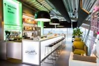 a bar in a restaurant with a counter and stools at Tulip Inn Eindhoven Airport in Eindhoven