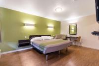 Un dormitorio con una cama y una mesa dentro. en Motel 6 San Rafael, en San Rafael