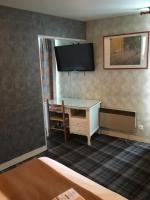a room with a desk and a tv on the wall at Hotel du Rempart in Sancerre