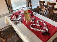 un tavolo con un cuore su una tovaglia rossa di Wolfshotel am Arendsee a Arendsee
