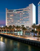 ein großes Gebäude mit Palmen vor einem Fluss in der Unterkunft Hard Rock Hotel &amp; Casino Biloxi in Biloxi