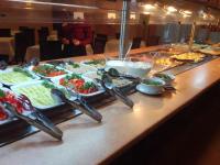 a buffet of food with tongs on a table at Romantik Spa Hotel in Yaremche