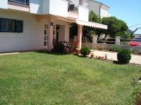 a house with a lawn in front of it at Apartman ŠTRK in Sukošan