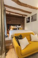 a bedroom with a bed and a yellow couch at Maison TANDEM in Cluny