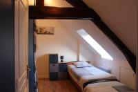 a bedroom with two beds in a attic at Gîte La Loussaudrie in Pontmain