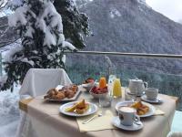 een tafel met borden eten bovenop een berg bij Chalet Morel 1586 Hotel & Spa in Limone Piemonte