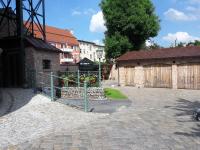 a courtyard with a fence and some buildings at Ferienhaus am Wasserturm Angermünde in Angermünde