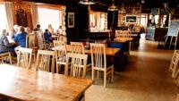 un ristorante con tavoli in legno e persone sedute ai tavoli di Loch Insh Chalets and Apartments a Kincraig