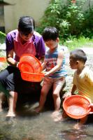 a man and two boys playing in the water with baskets at Fairy Story Village Farm B&amp;B in Dongshan