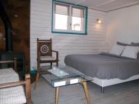 a bedroom with a bed and a chair and a table at Entre Mer et Marais Salants in Guérande