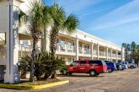 Un camión rojo estacionado frente a un edificio en Motel 6-Saraland, AL, en Saraland