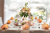 Una mesa con un mantel blanco y un jarrón de flores. en Hotel Wodnik, en Łeba