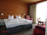 a bedroom with a bed and a wooden wall at Gasthof Panorama in Obsteig