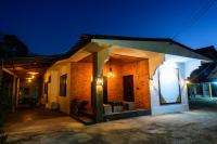 una casa de ladrillo con una fachada iluminada por la noche en Huan Amphan, en Chiang Rai