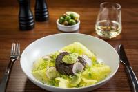 a white bowl of food on a wooden table at Fable Auckland, MGallery in Auckland
