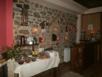 a stone room with a table with food on it at Thea Valtessinikou in Valtessiniko