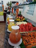 un buffet di frutta e succhi su un tavolo di Tureck Garten Hotel a Corupá