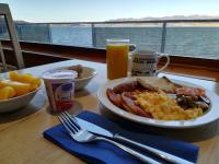 un tavolo con un piatto di prodotti per la colazione e una finestra di Loch Insh Chalets and Apartments a Kincraig