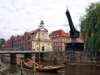 un barco en el agua junto a un puente en DORMERO Hotel Altes Kaufhaus Lüneburg, en Lüneburg