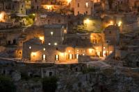 a view of a village at night at Basiliani Hotel in Matera