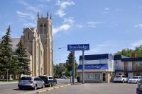 un letrero de la calle frente a un edificio con iglesia en Travelodge by Wyndham Moose Jaw, en Moose Jaw